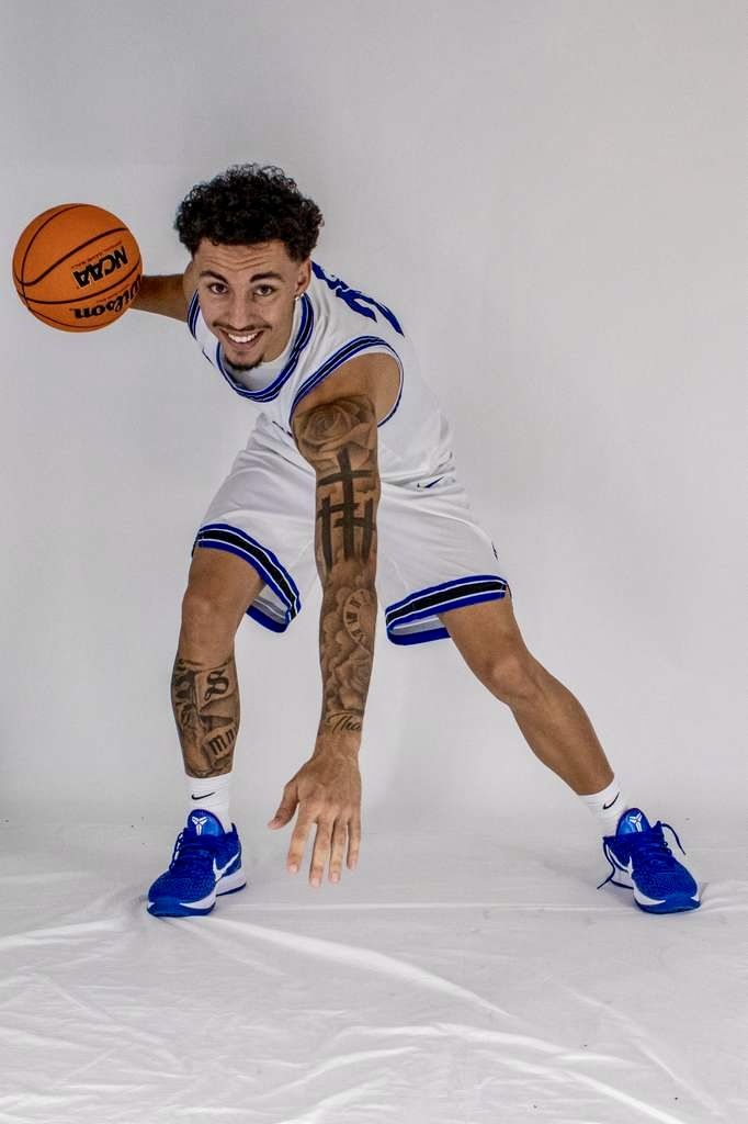 Kyanu low in a dribble stance on a white studio backdrop